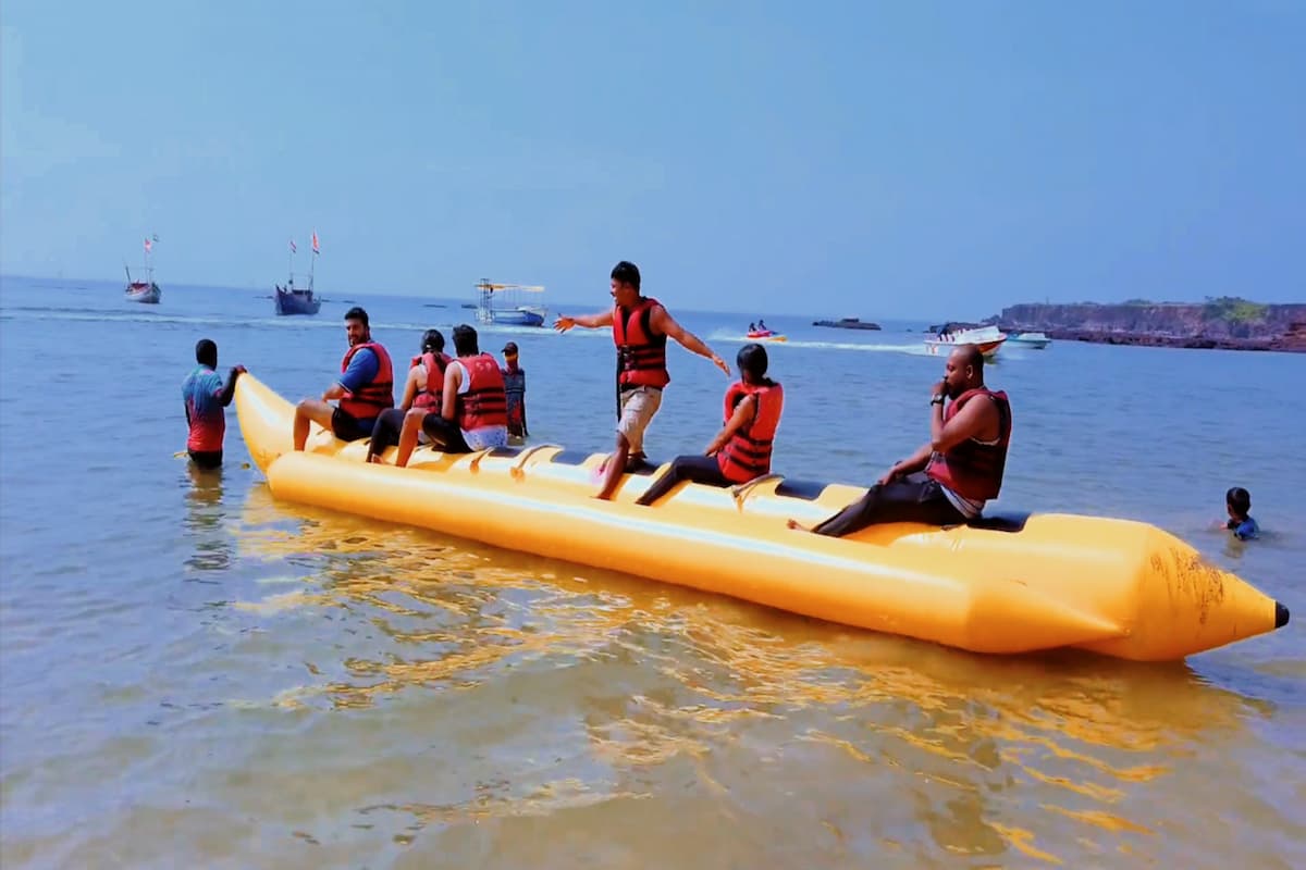 Tourists Enjoying a fun-filled banana boat ride in Goa, holding on tightly as the inflatable bounces over ocean waves