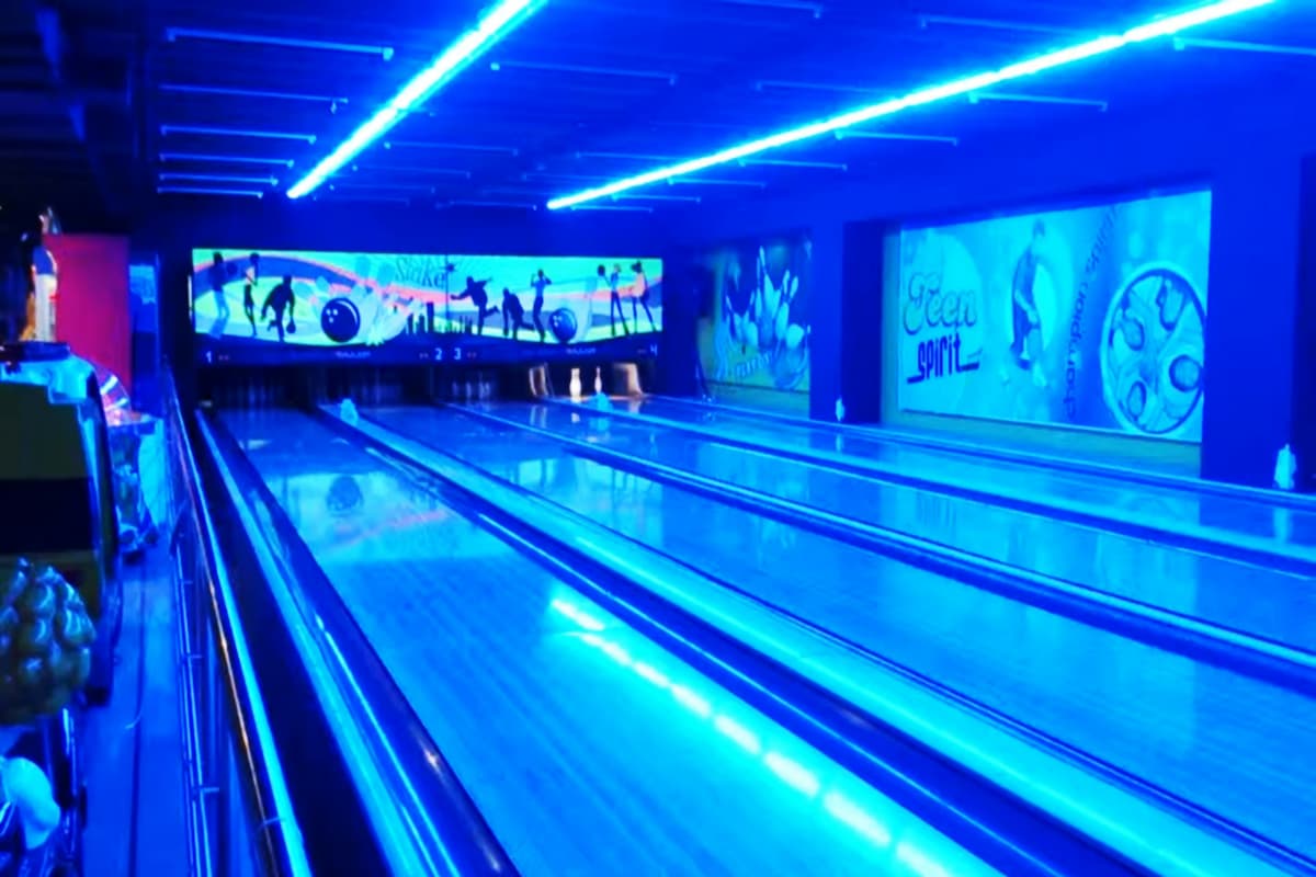Friends Enjoying a relaxed evening playing bowling and pool in an indoor entertainment center in Goa, away from the sun