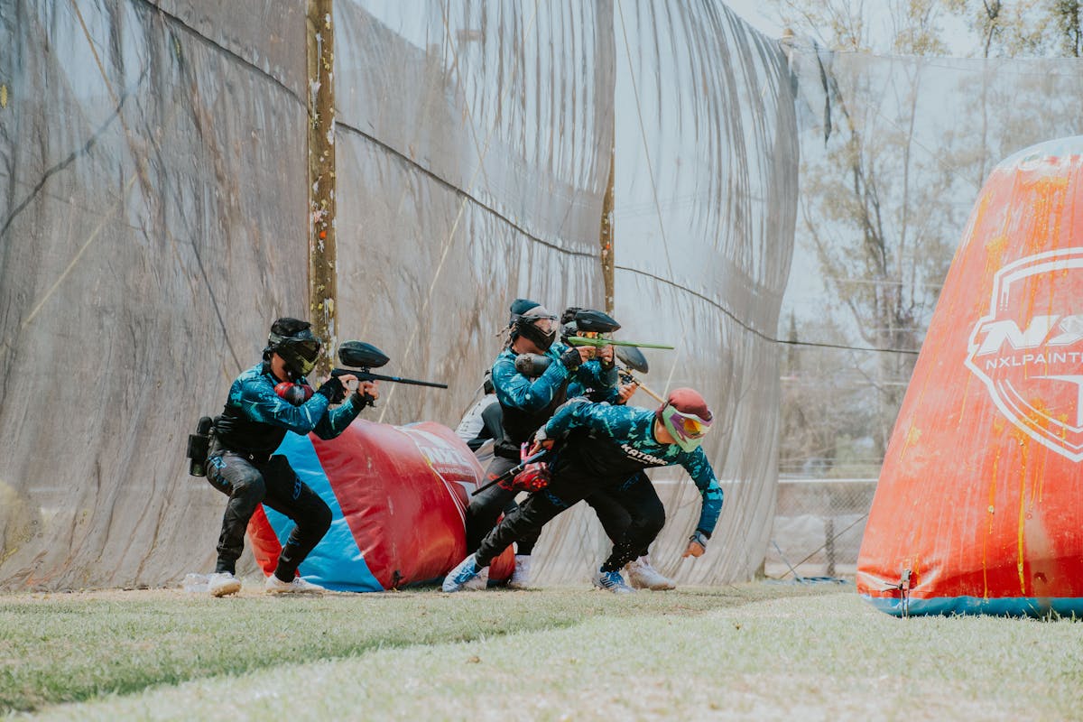 Group of Friends Playing a Colorful paintball match in Goa, taking cover and strategizing amidst splashes of vibrant paint
