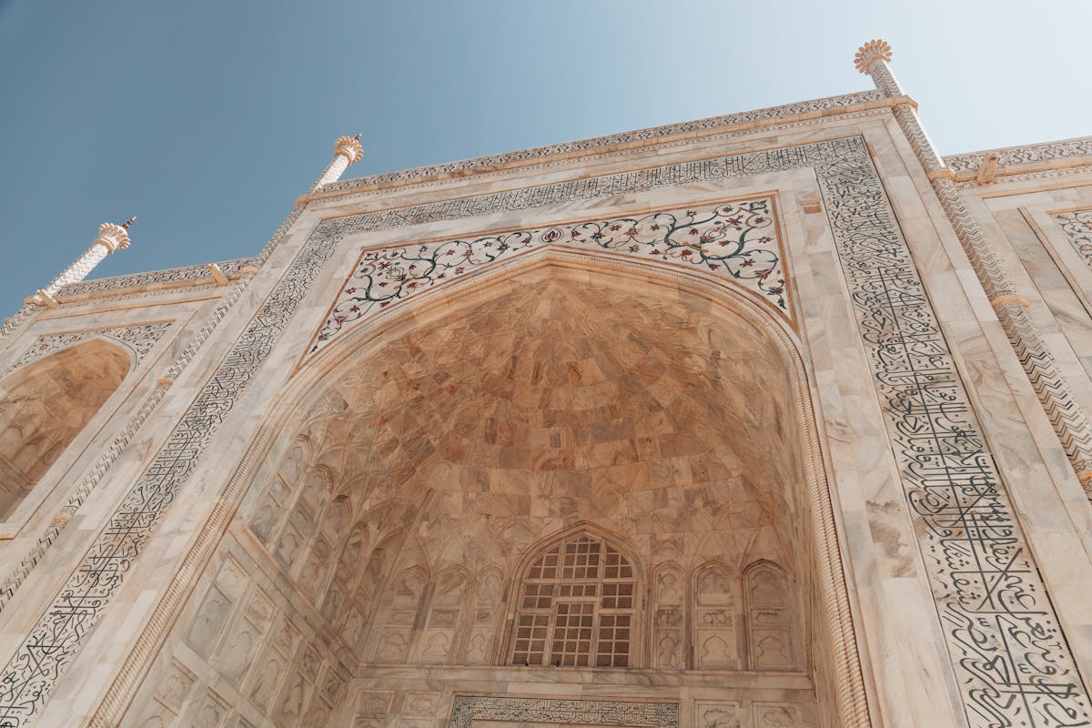 Architectural close-up showing Persian dome, Islamic arches, and Indian floral motifs on the Taj Mahal